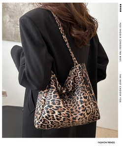 Detail shot of leopard print canvas tote bag on model shoulder with large capacity