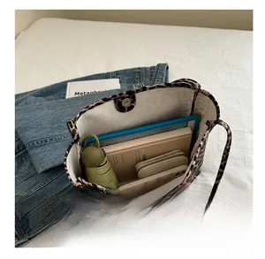 Detailed interior view of a leopard print canvas tote bag showing large storage capacity