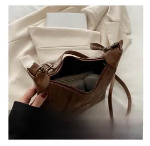 Top-down view of spacious interior of brown crossbody bag showing zipper closure