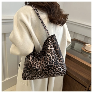 Chic leopard print oversized canvas tote bag shown on a model in a minimalist setting