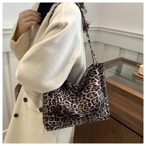 Detailed side view of large leopard print tote bag worn on shoulder in a cozy interior