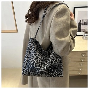 Side view of large leopard print canvas tote bag styled with a beige blazer for commute