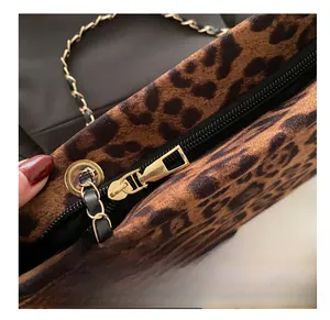 Detail of vintage leopard print tote showing smooth gold metal zipper and chain strap