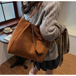 Dettaglio borsa tote in pelle scamosciata marrone con catena d'argento e perline