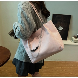 Dettaglio della borsa tote rosa con catena argento, perline e etichetta fashion