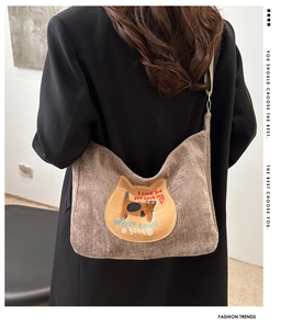 Detail view of brown corduroy crossbody bag with cute cat patch and casual aesthetic