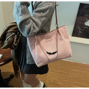 Dettaglio della borsa tote in finta pelle scamosciata rosa con catena in metallo e perline