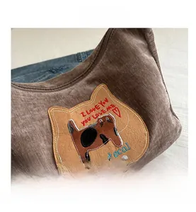 Detail of cute cat embroidery patch on brown corduroy tote bag with I LOVE YOU text