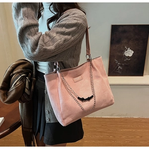 Dettaglio della borsa tote rosa con catena in metallo argento con perle nere e texture