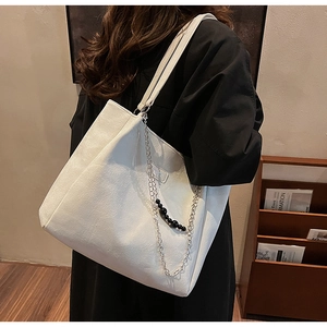 Grande borsa tote bianca con catena d'argento e ciondolo di perle nere a spalla