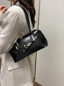 Minimalist black glossy shoulder bag with gold buckles and chic Y2K aesthetic style