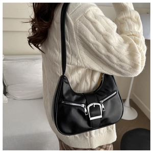 Sac hobo croissant noir rétro avec boucle argentée porté sur un pull en maille beige