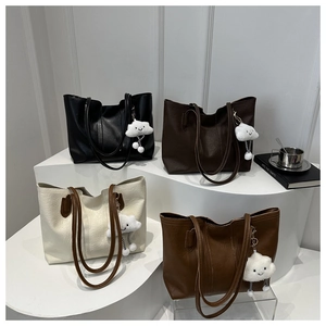 Close-up of four minimalist faux leather tote bags with cloud charms on display stands