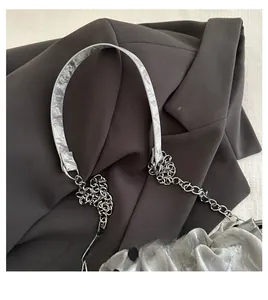 Detail of silver pleated bucket bag featuring metal chain strap and smooth top handle