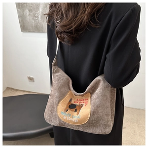 Macro shot of brown corduroy cat tote bag with embroidery details and shoulder strap