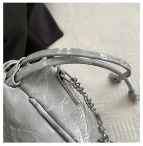 Detail of silver chain and distressed metallic crinkle texture on the drawstring bag