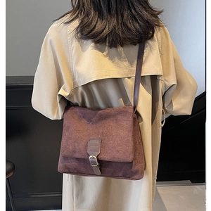 Vintage brown suede messenger bag worn by model for high-end autumn winter styling