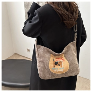 Detail of dark brown corduroy tote bag with cat embroidery and adjustable strap