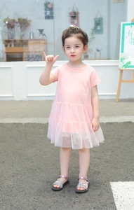 Detail of pink summer dress for girls featuring layered tulle mesh skirt and light fabric