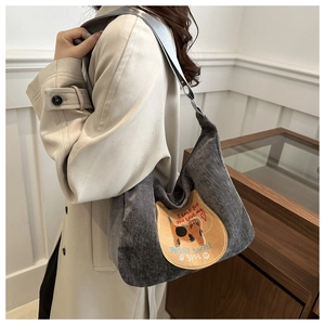 Detail of grey corduroy hobo bag with cute cat patch and shoulder strap for winter