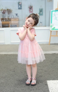 Detail of pink summer girl dress showing fluffy multilayered tulle skirt and soft cotton top