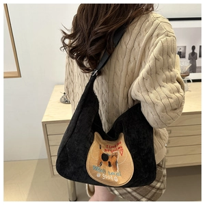 Detail of black corduroy hobo bag with cute cat embroidery and stylish shoulder strap