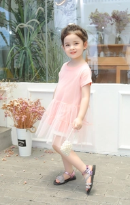 Pink cotton short sleeve dress with tiered mesh skirt shown in an outdoor setting
