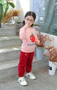 Detailed view of pink cotton sweatshirt with tomato print and dark red joggers for girls