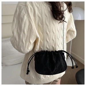 Detail of black cloud bag with pleated fabric and silver chain strap on model