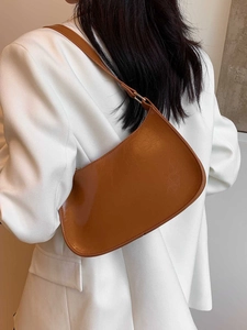 Sac hobo vintage marron caramel avec texture cuir craquelé porté à l'épaule