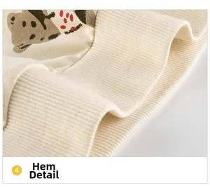 Detailed close-up of ribbed knit hem on a girls' cream sweatshirt with cartoon print