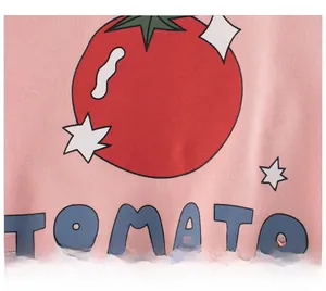 Close-up of pink cotton fabric with a red tomato print and blue Tomato lettering