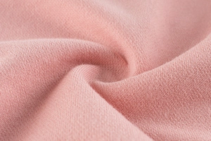 Close-up of soft pink knitted cotton fabric texture for children sweatshirt