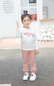 Detail of girls' white letter print T-shirt and pink joggers with heart-shaped patches