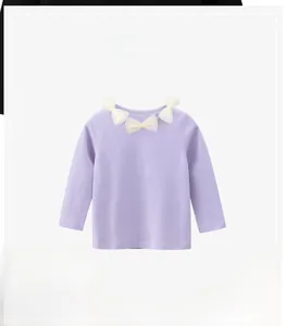 Dettaglio della maglietta lilla per bambina con fiocchi di tulle decorativi sullo scollo