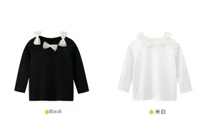 Dettaglio magliette a maniche lunghe da bambina in nero e bianco con fiocchi di tulle