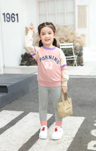 Detail view of girls pink patchwork sweatshirt with morning lettering and grey leggings
