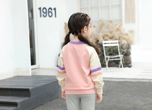 Detail of pink and white color block kids sweatshirt with striped sleeves in soft cotton