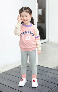 Outdoor street style shot of kids patchwork sweatshirt with Morning 82 graphic print