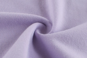 Dettaglio macro del jersey di cotone lavanda che mostra la texture morbida e la maglia