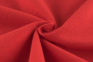 Close-up of premium red knitted cotton fabric with a soft texture and fine ribbed details