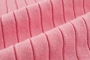 Close-up of pink ribbed knit fabric showing vertical texture and soft material detail