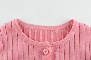 Detailed close-up of pink knit cardigan showing round neck and ribbed texture