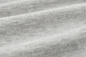 Close-up of soft light grey knit fabric texture for girls casual autumn pants