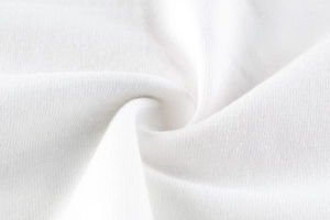 Close-up of white knit cotton fabric showing soft micro-texture and premium rib details