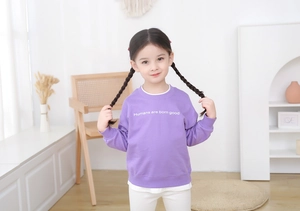 Detail of lavender purple girls' sweatshirt featuring white slogan text and soft cotton fabric