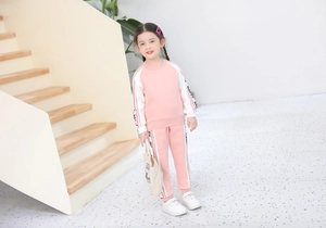 Dettaglio della tuta sportiva rosa e bianca da bambina con nastro Happy e morbido cotone
