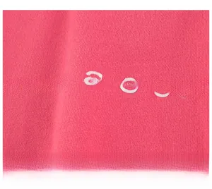 Close-up of pink knit fabric with white letter printing on kids casual sweatshirt