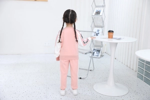 Vista posteriore della tuta rosa da bambina con scritte HAPPY sulle maniche bicolore
