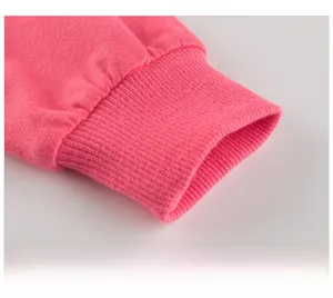 Close-up of bright pink ribbed cuffs showing detailed knitted fabric texture on girl's top